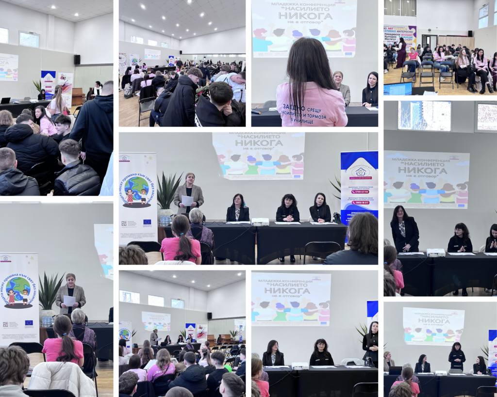 Panel discussion at a long table in a conference hall, audience seated and a projection showing a colorful banner behind them.